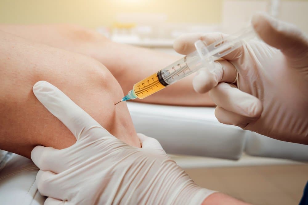 Close-up of a provider injecting PRP into a patient's knee